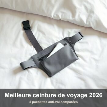 Pochette ventrale de voyage en tissu gris posée à plat sur un lit d'hôtel à côté d'un passeport fermé